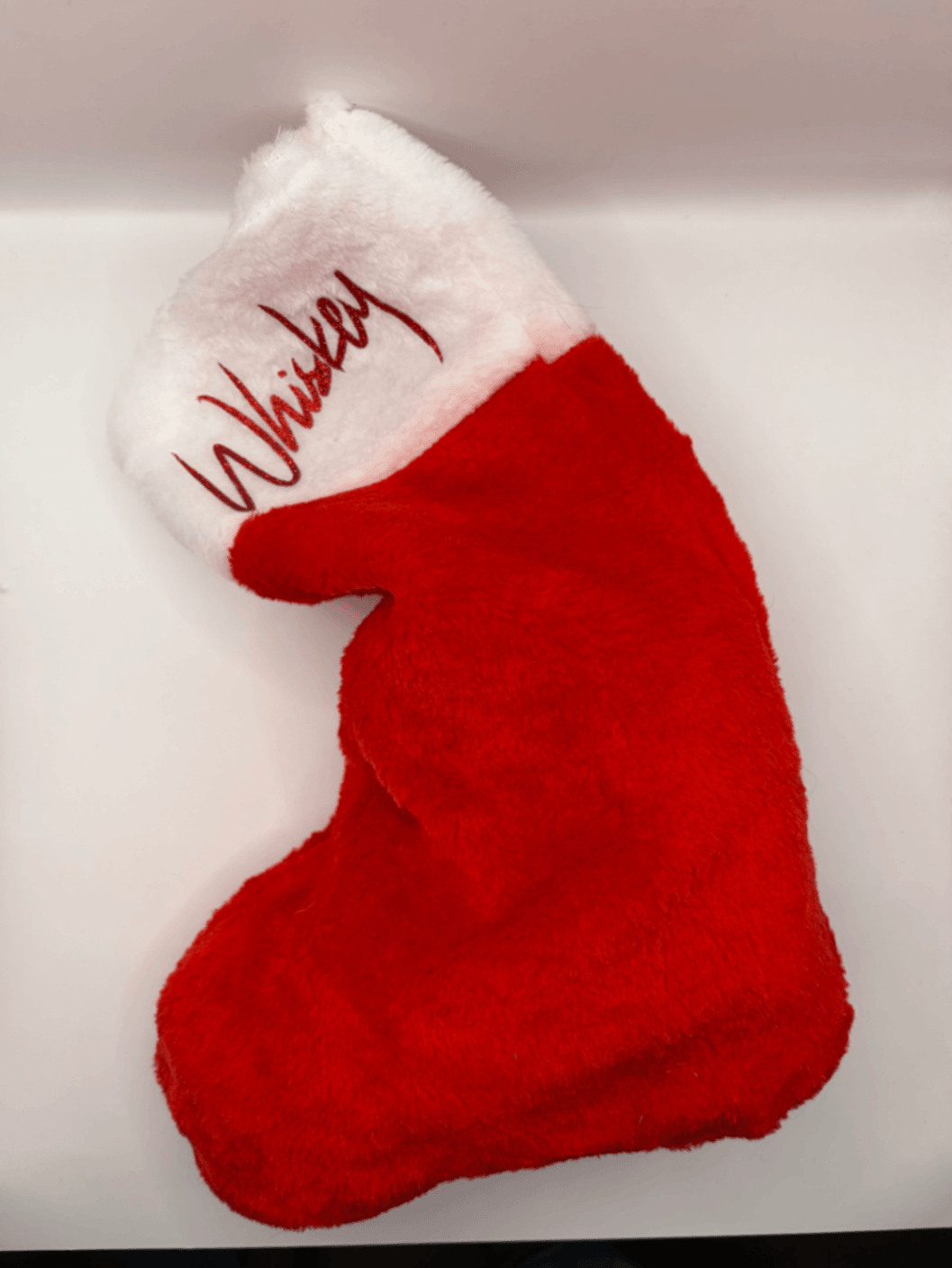 Side view of a red and white personalised Fur Baby Christmas stocking