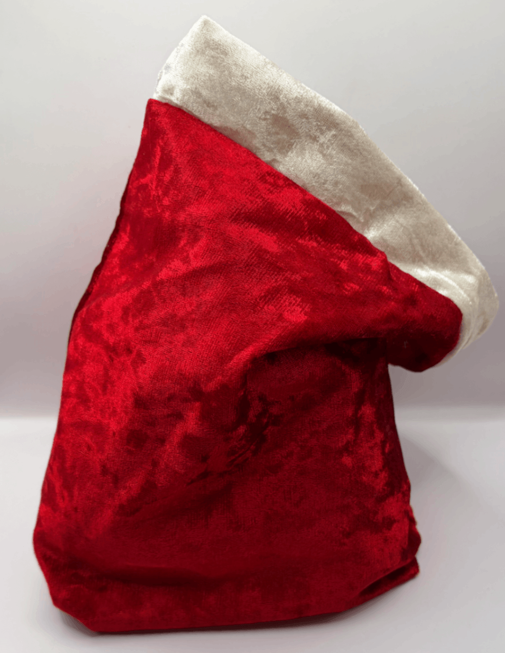 Side view of a red velvet Fur Baby Santa Sack with white trim